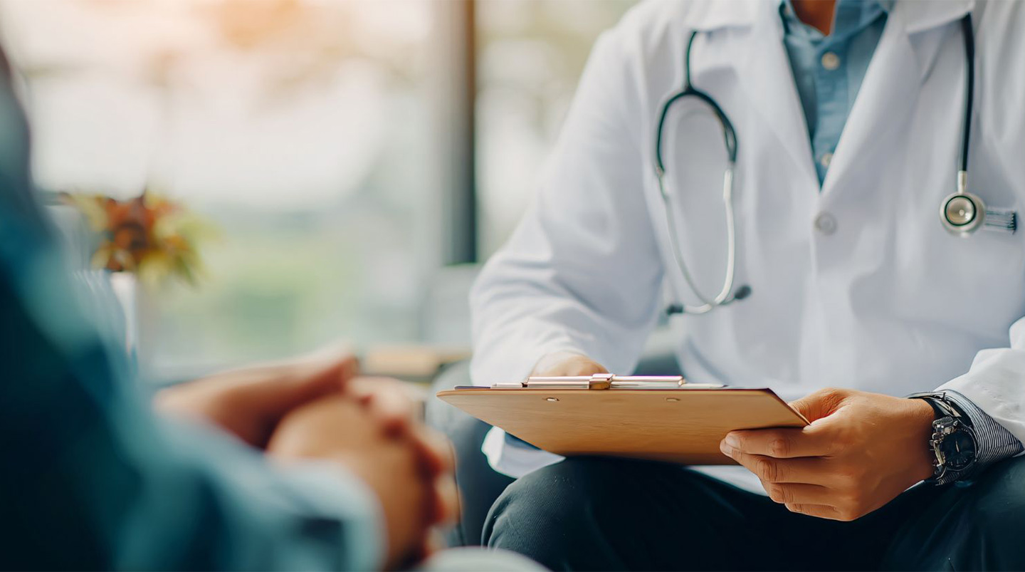 Doctor consulting with patient, reviewing medical records.