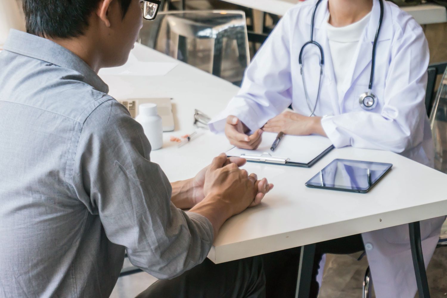 A doctor in a white coat consults with a patient.