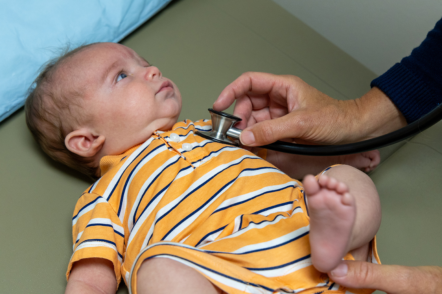 Doctor listens to baby's heart with stethoscope.