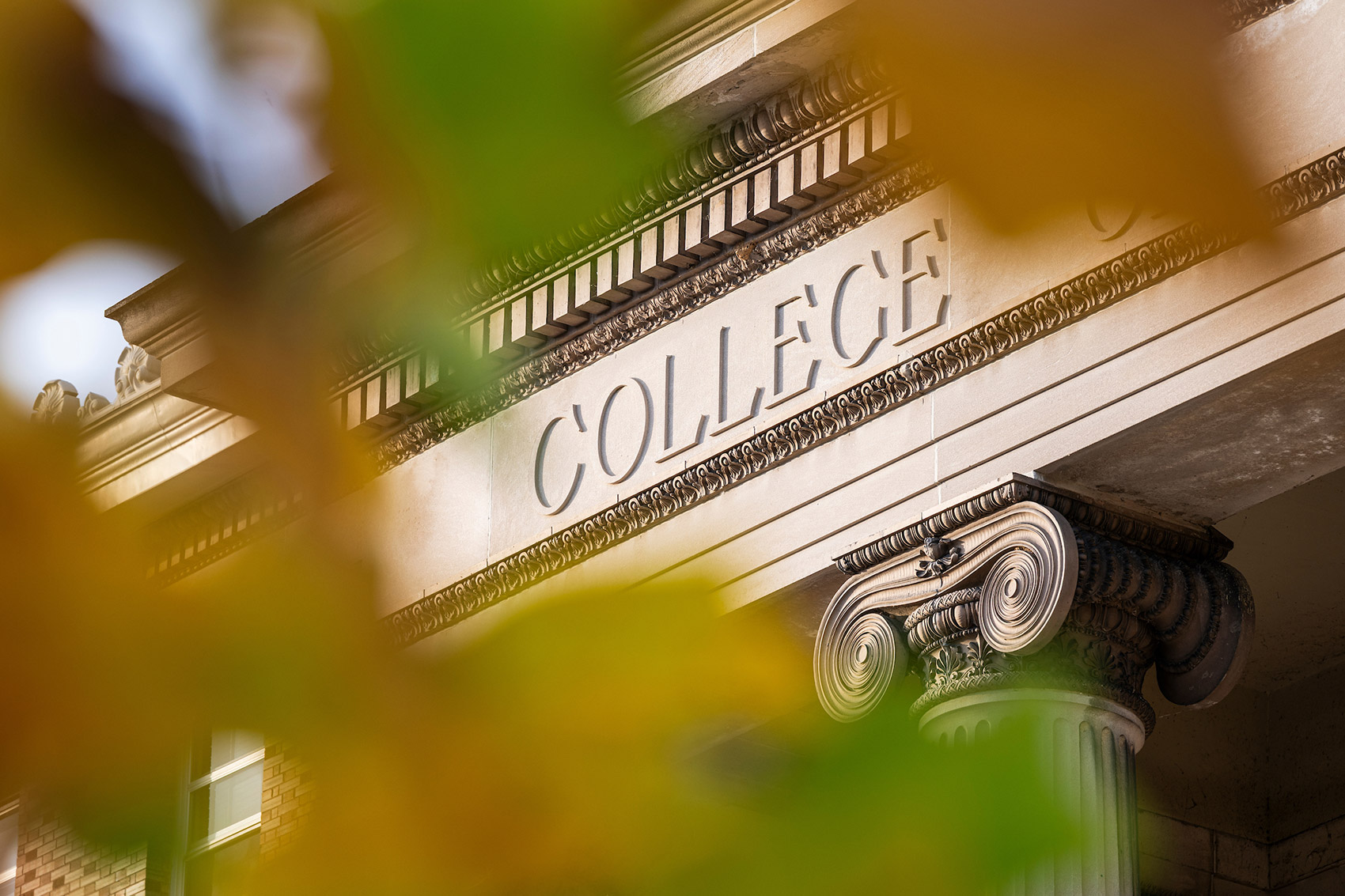 The ornate columns and lettering of Agriculture Hall is framed by colorful fall leaves on a sunny autumn day at the University of Wisconsin–Madison.