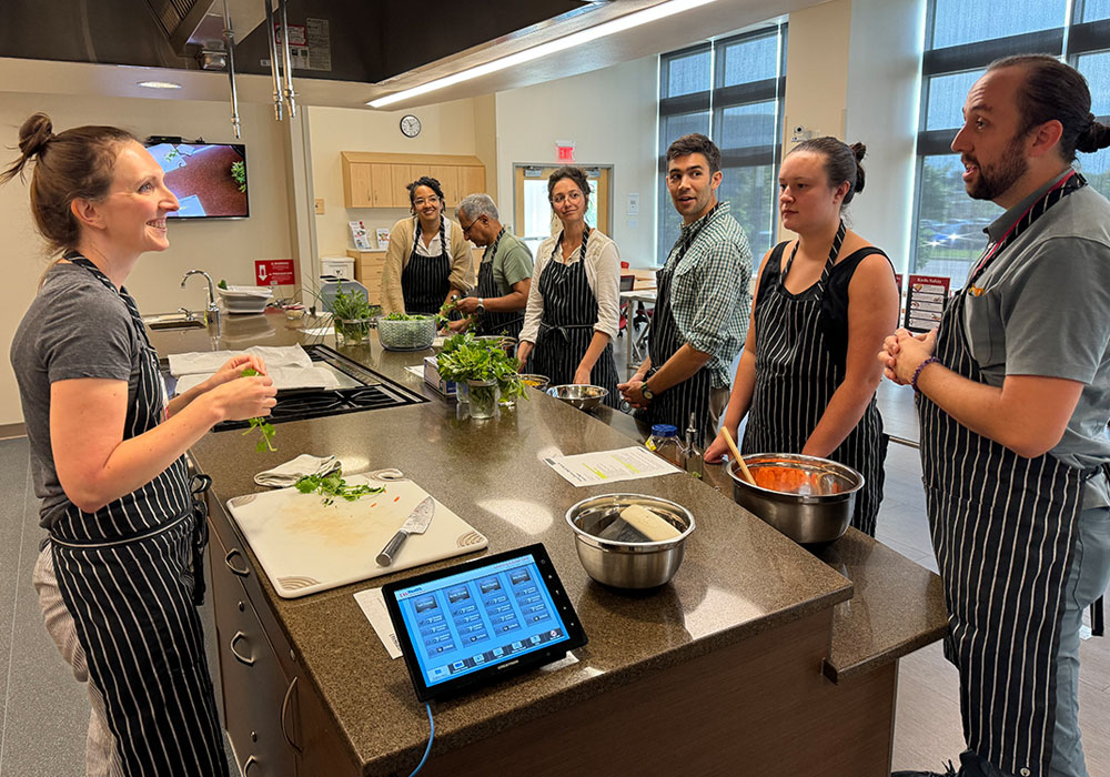 Fellows at a kitchen counter learning to prepare food.