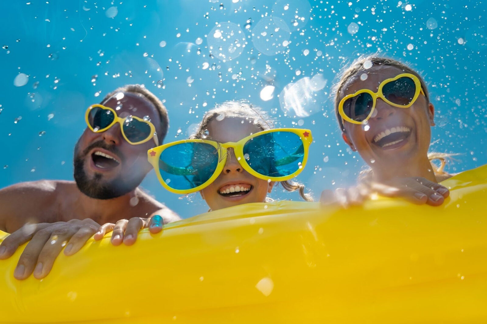 Family having fun on inner tube at waterpark during summer.