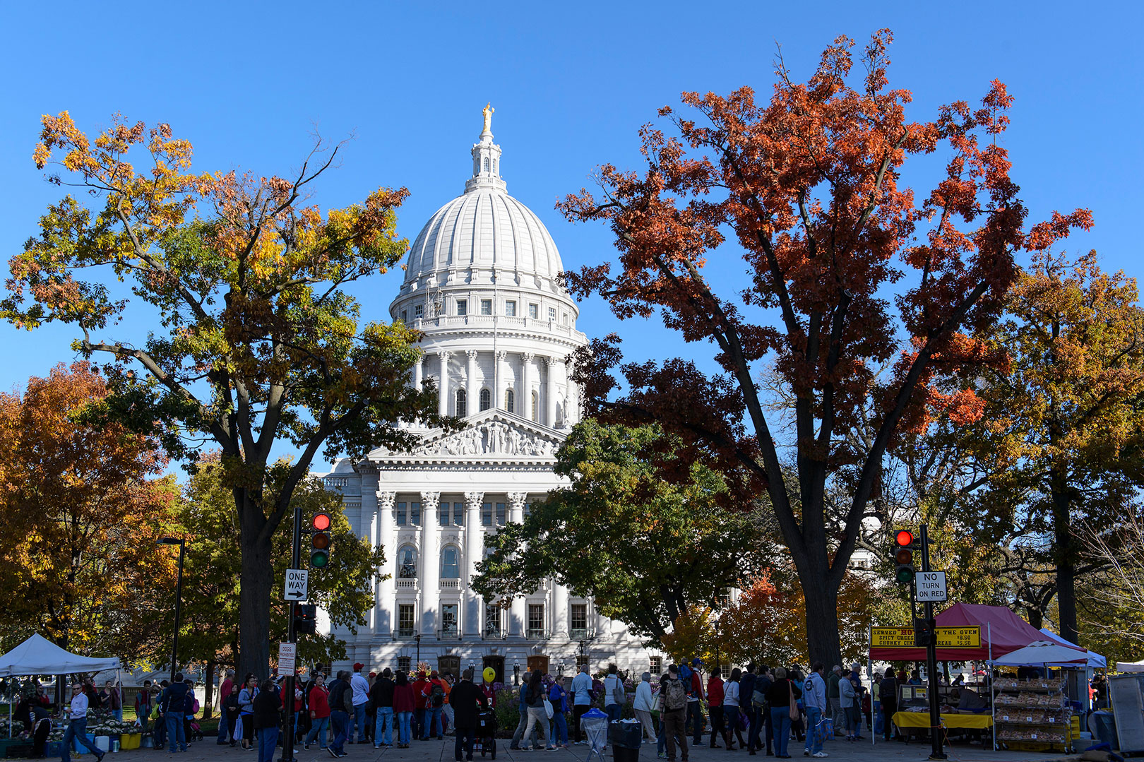 Golden tree foliage frames a view of the Wisconsin State Capitol.