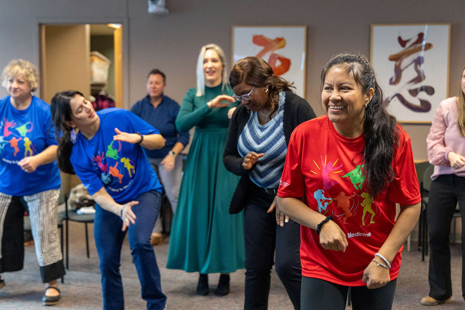 Group of adults exercising at an Osher event, in a classroom setting.