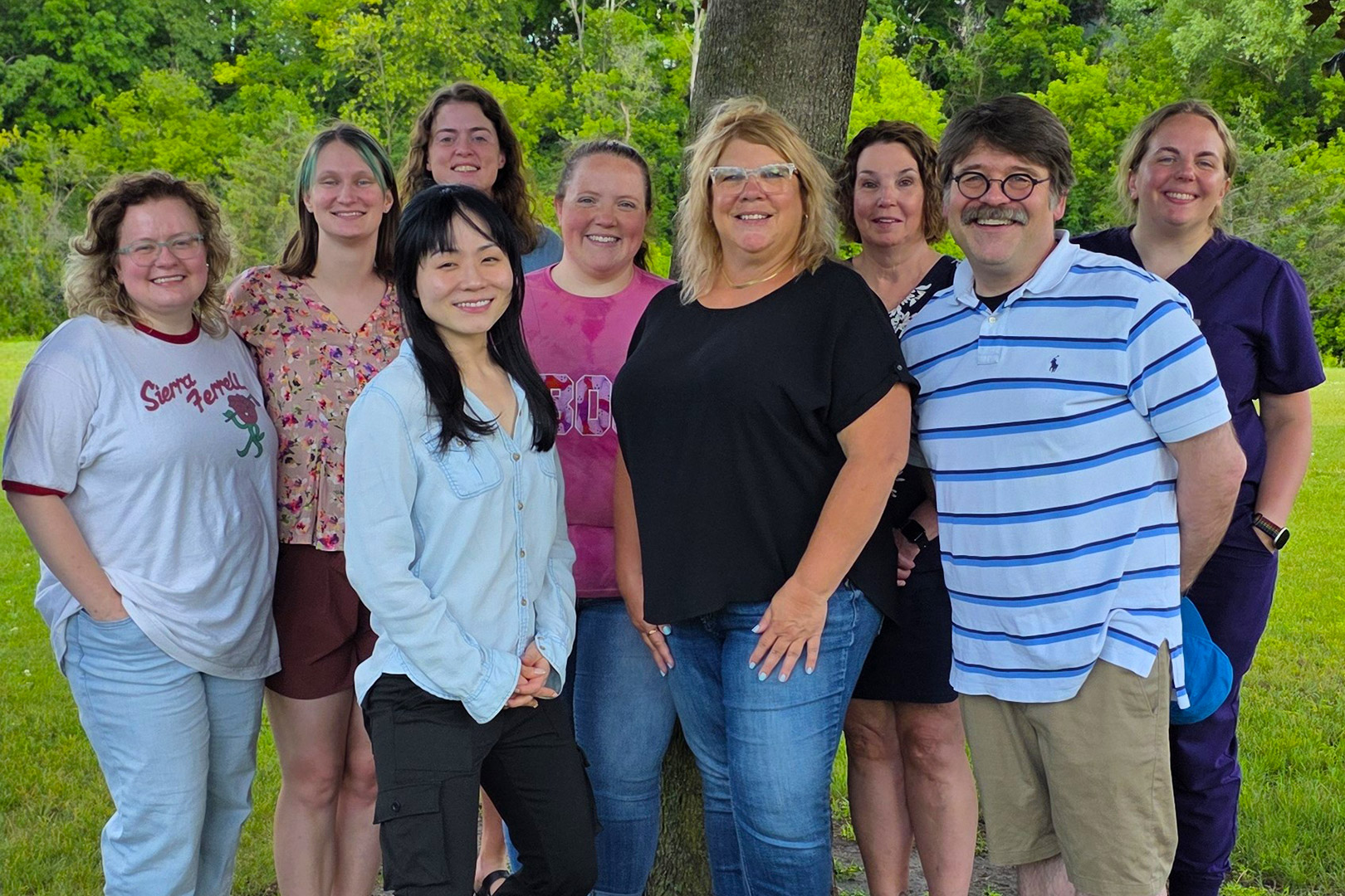 Baraboo residents and faculty at a park, under a tree, on a sunny day.