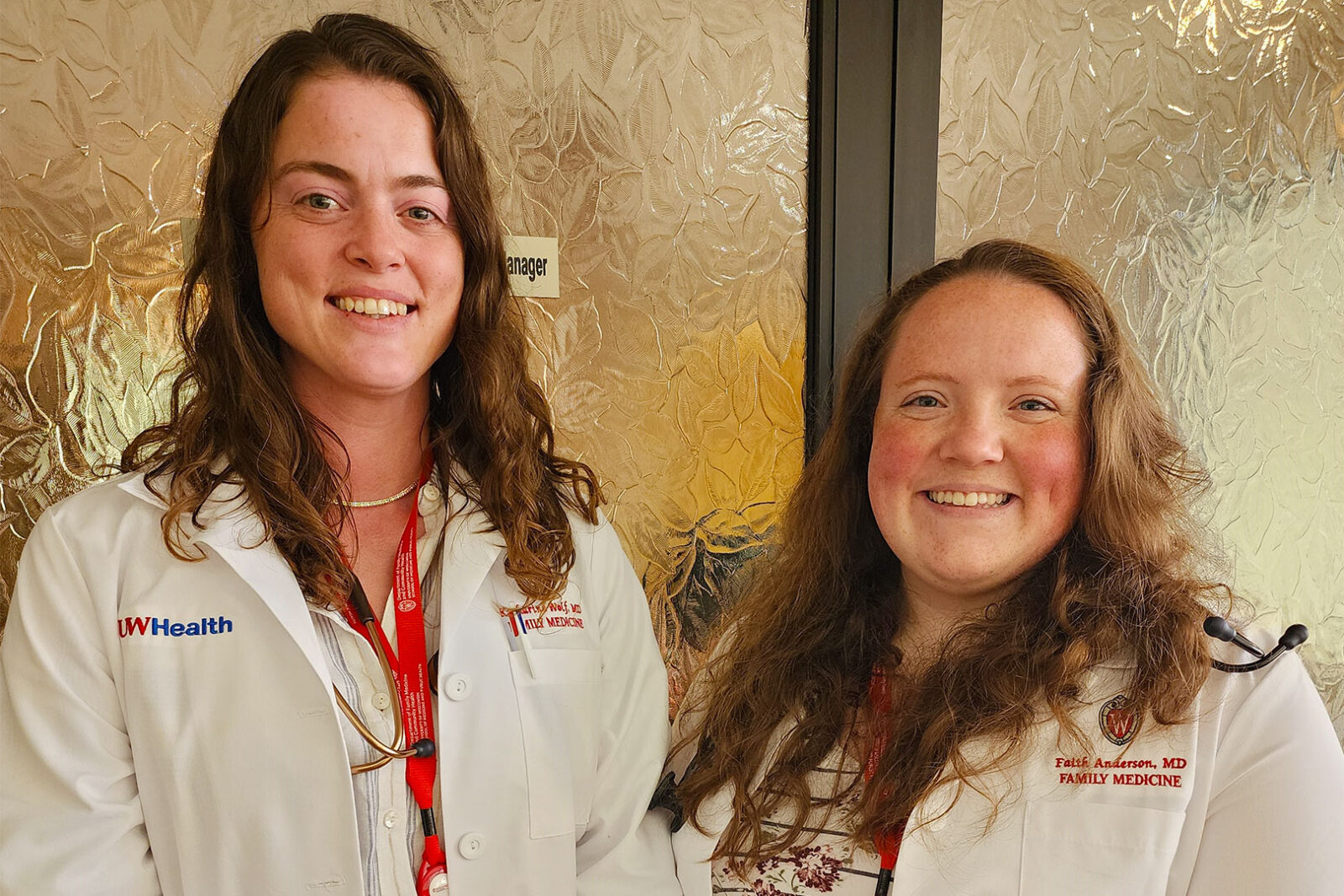 Baraboo residents, Kate Wolf, MD, PhD, and Faith Anderson, MD, in front of lobby door.