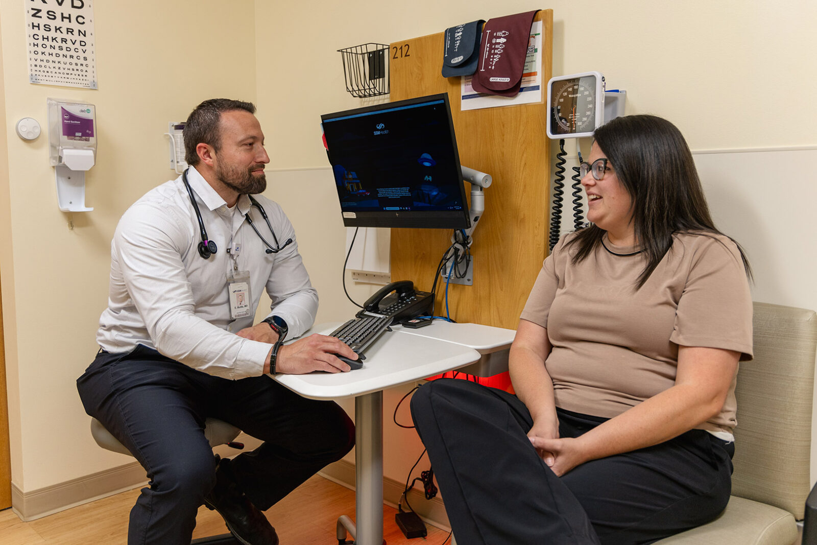 Doctor listening to a patient in a Monroe clinic room.