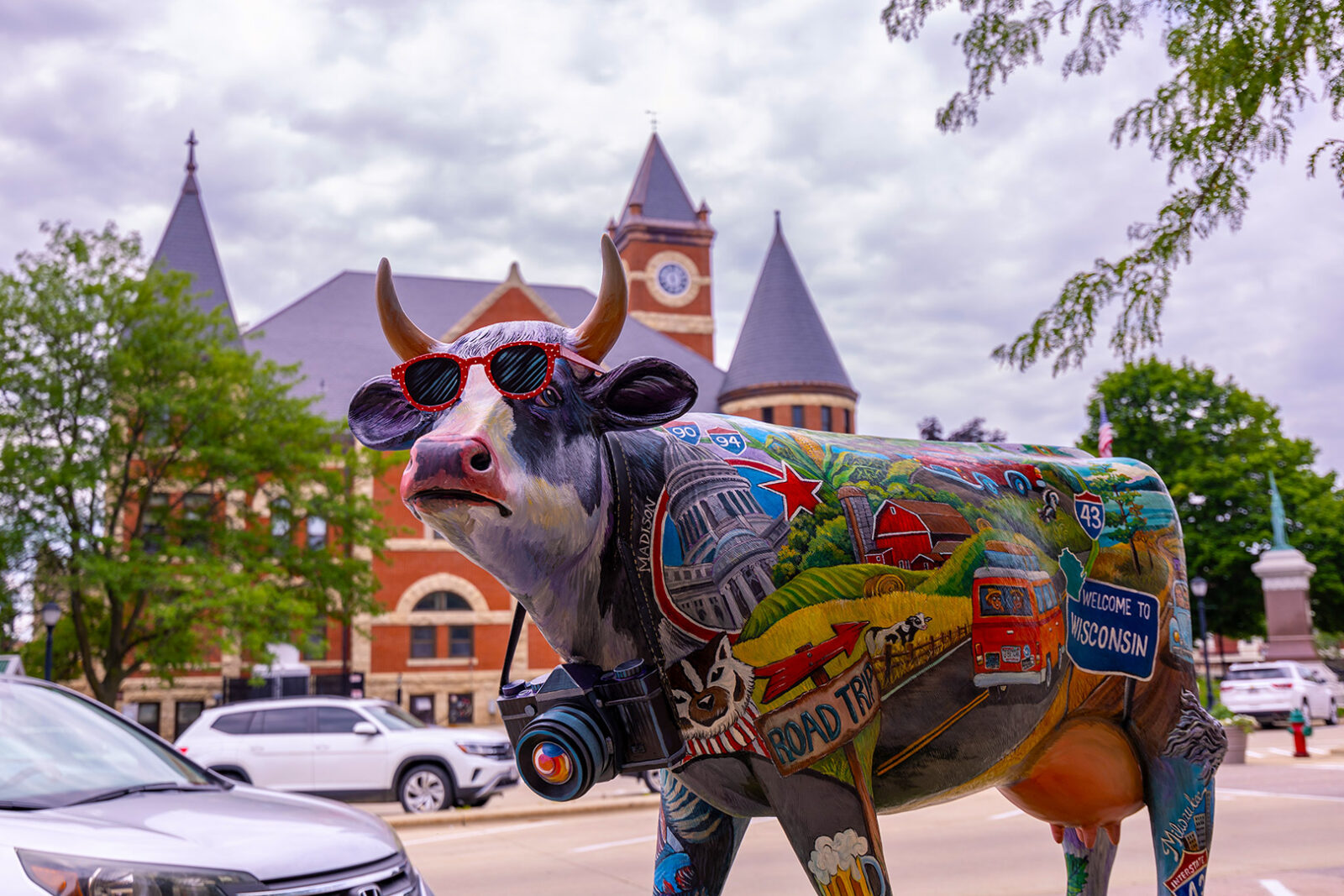 Painted cow statue with a collage of iconic Wisconsin things and places in downtown Monroe, WI.