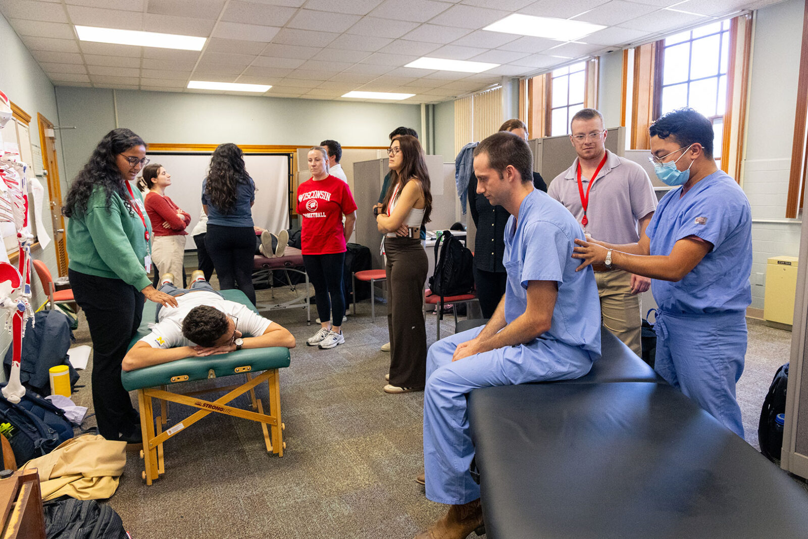 Residents learning Osteopathic Manipulative Treatment (OMT) techniques in a class setting.