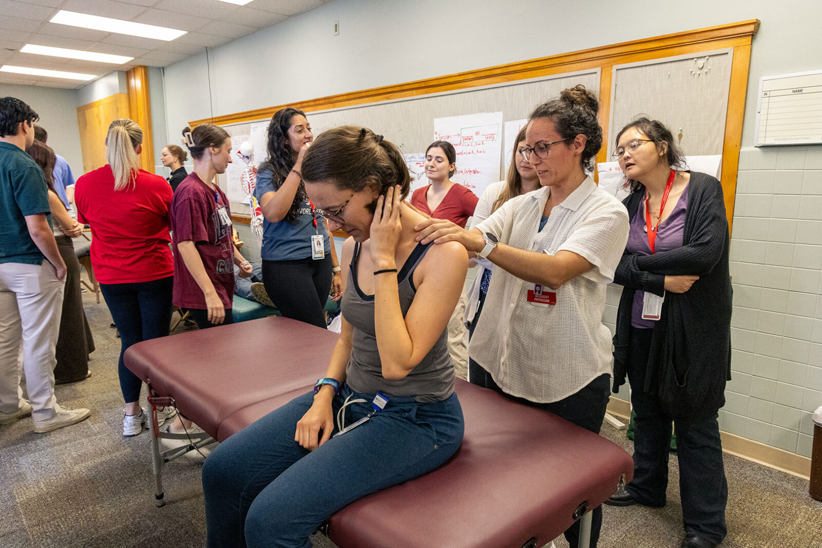 Residents learning Osteopathic Manipulative Treatment (OMT) techniques in a class setting.