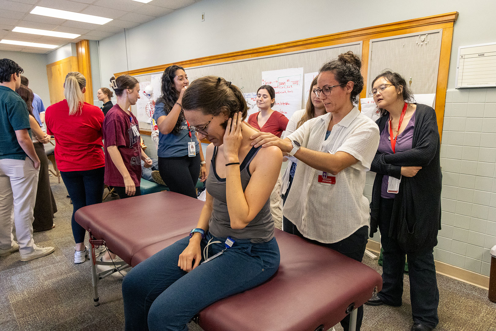 Residents learning Osteopathic Manipulative Treatment (OMT) techniques in a class setting.