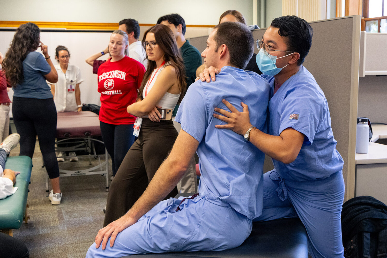OMT class where residents are practicing on each other and watching instructors.