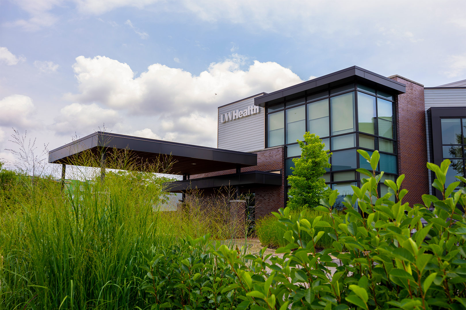 Yahara clinic exterior on a blue sky summer day with prairie flowers in the foreground.