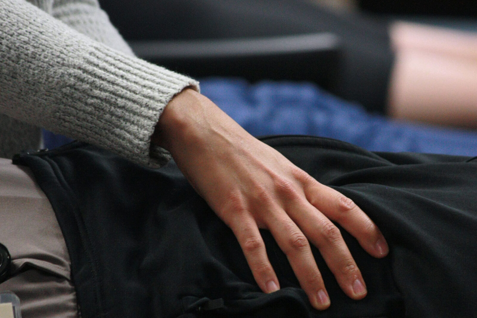 A close up of an osteopathic resident's hand treating a patient's leg.