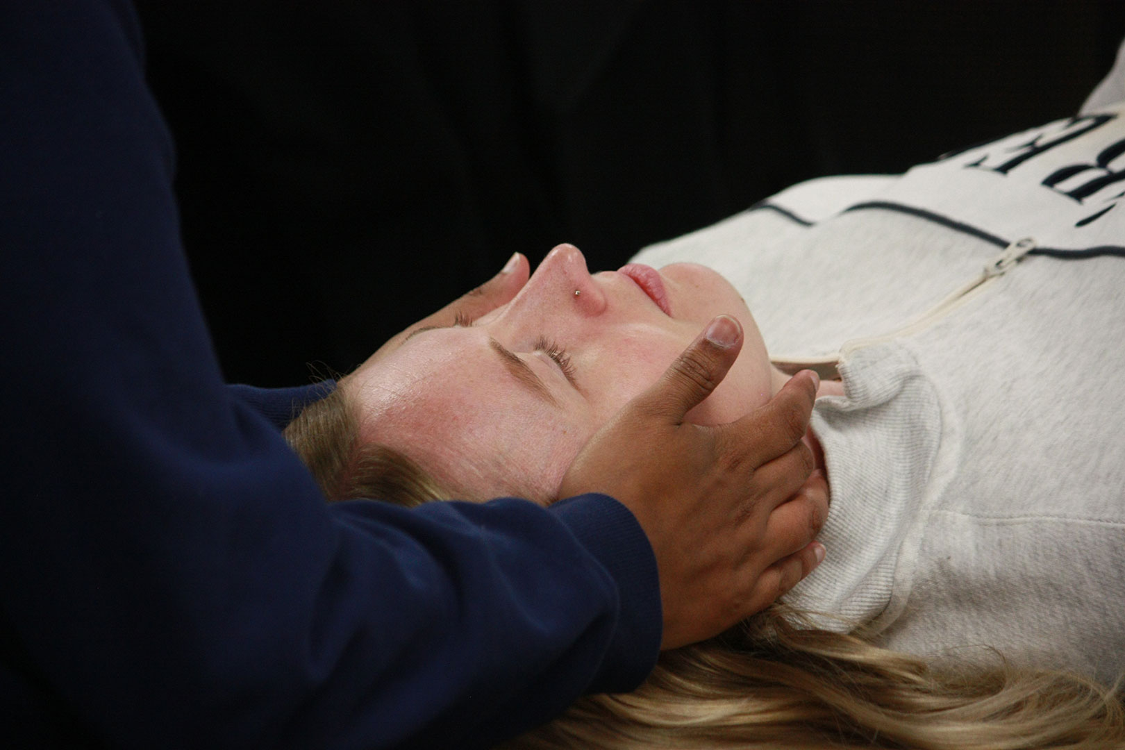 A close up of an osteopathic resident's hand treating a patient's neck.